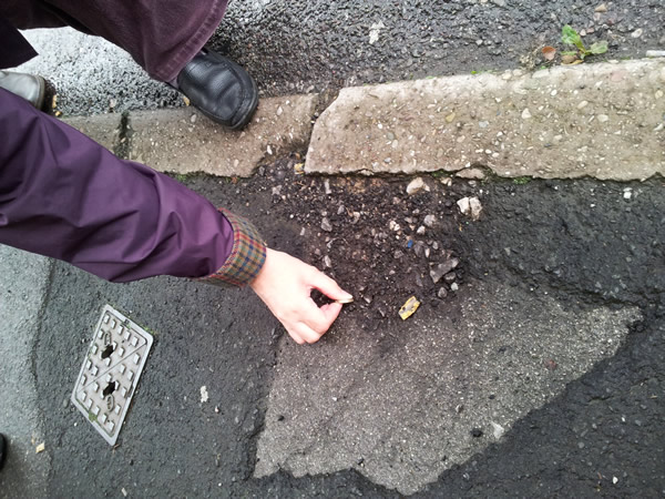 Hole in pavement of depth 2cm, tested with pound coin